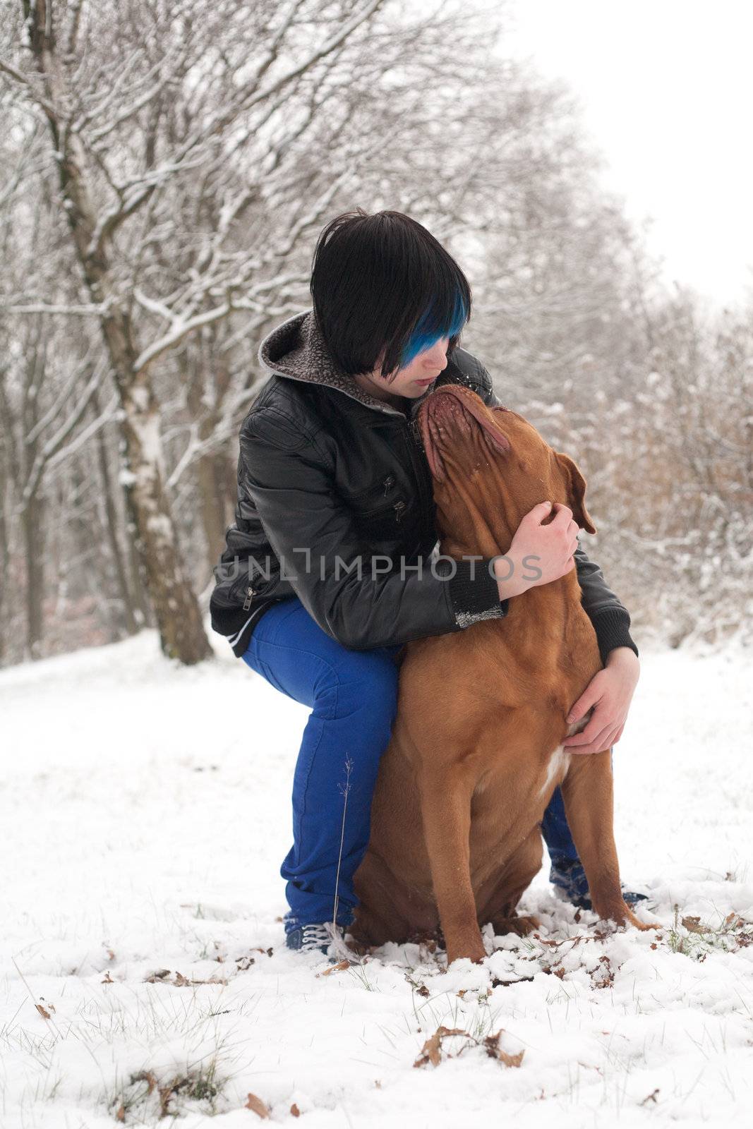 Funky boy is having fun with his dog in the snow