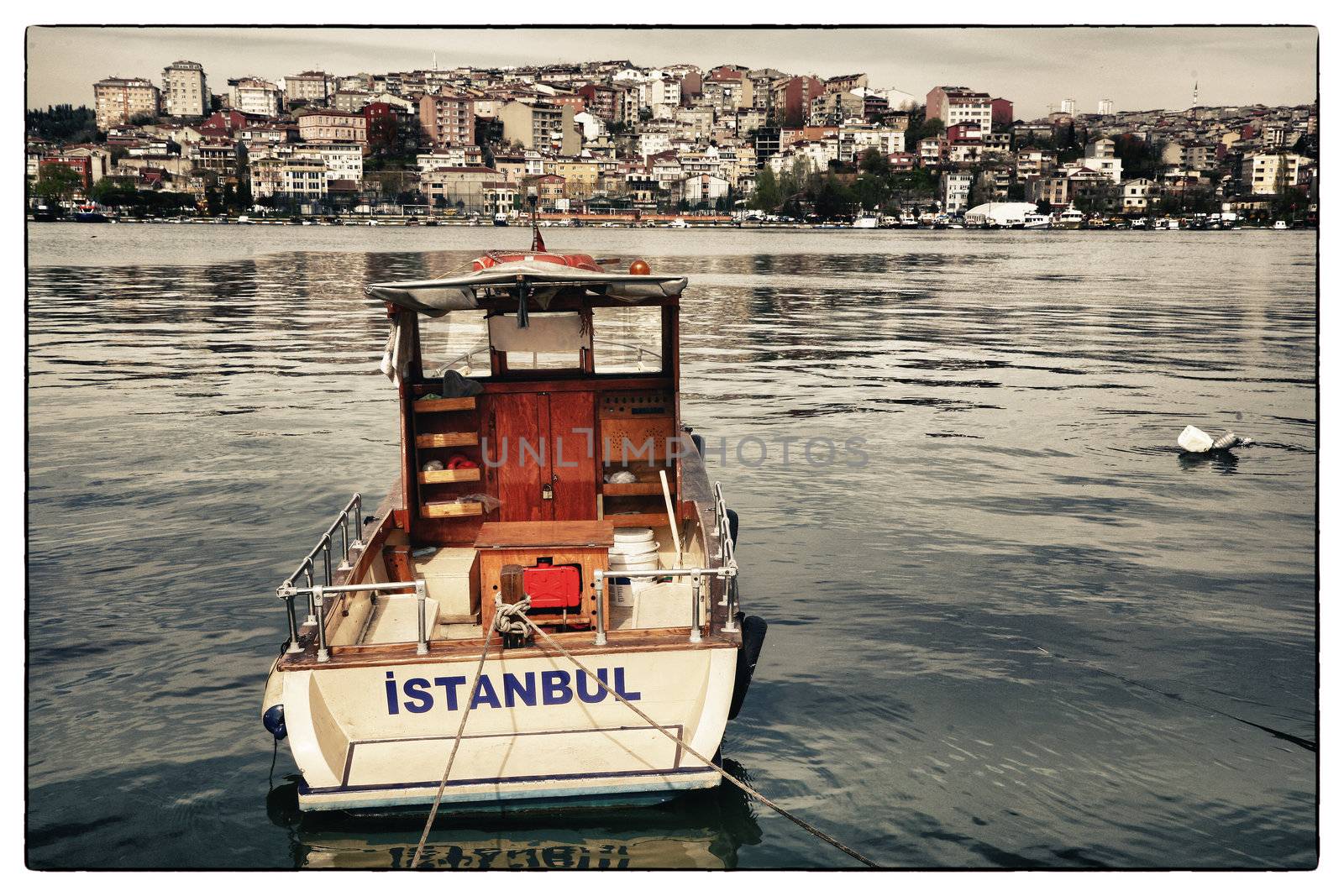 Postcard from Istanbul. Motor boat by the Golden Horn - Istanbul, Turkey. The Beyoglu district in the background.