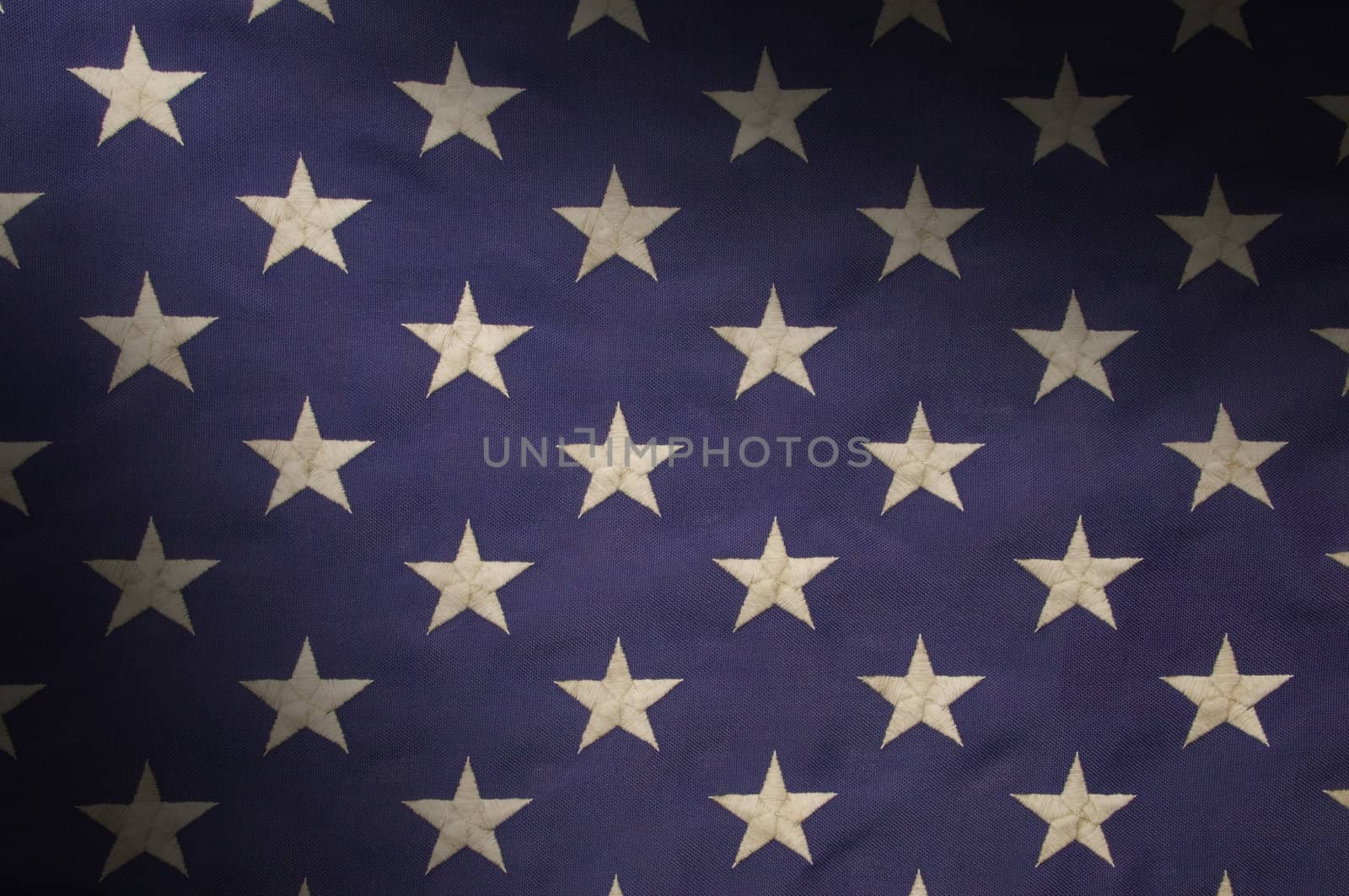 Embroidered white stars on a field of blue which represents the union on the American flag, lit diagonally