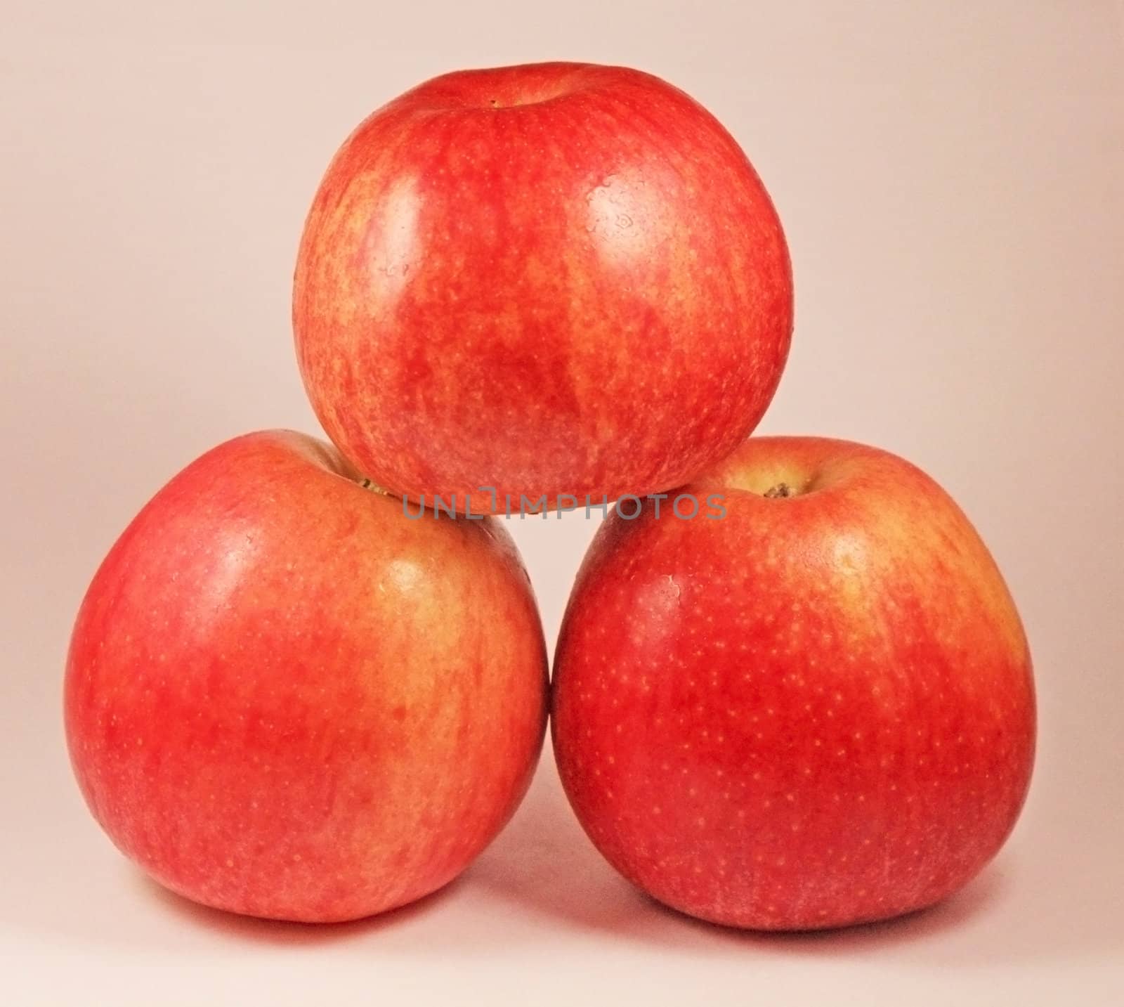 The pyramid of three red isolated apples