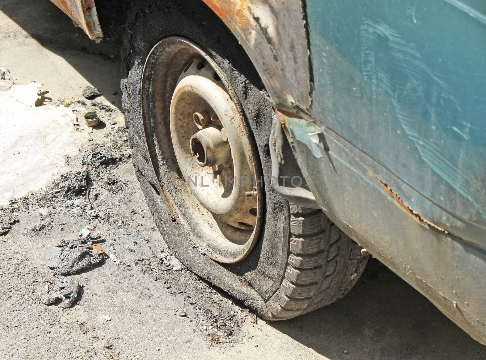 A wheel of fully burned car in the street