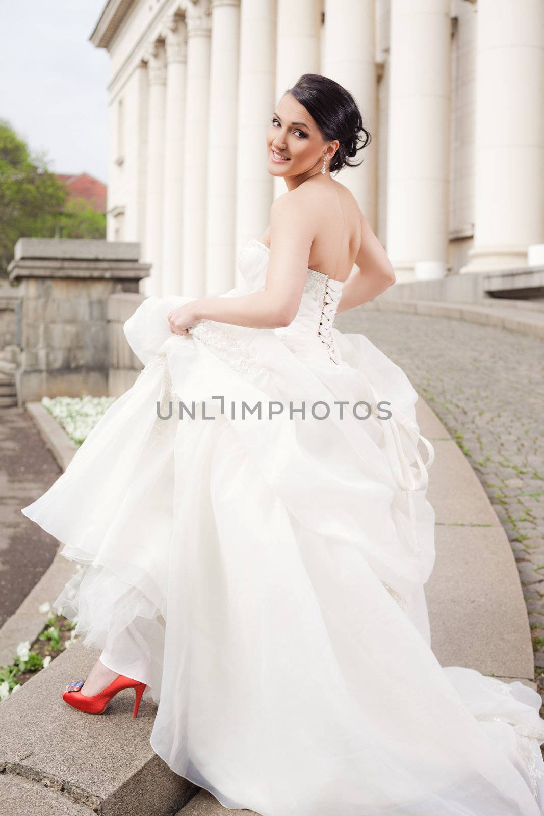 Beautiful bride standing with wedding dress smiling at camera