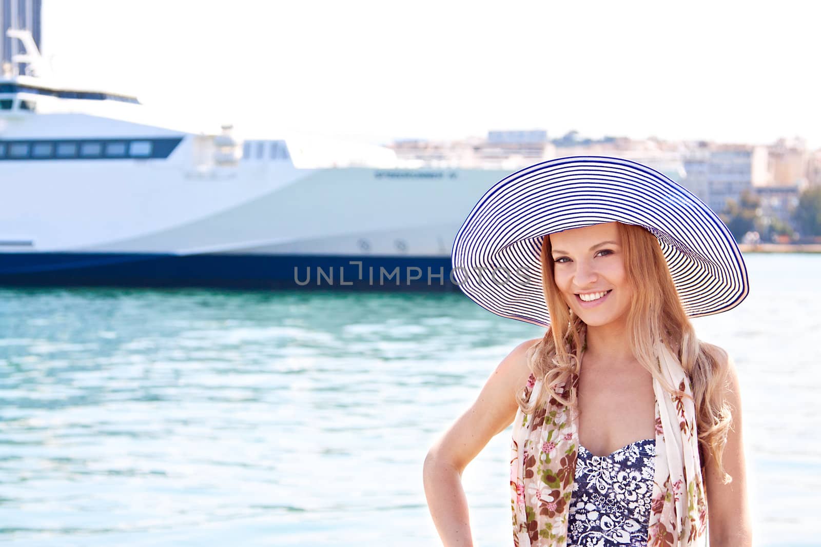 Portrait of a young and beautiful girl in the background of a large ocean liner