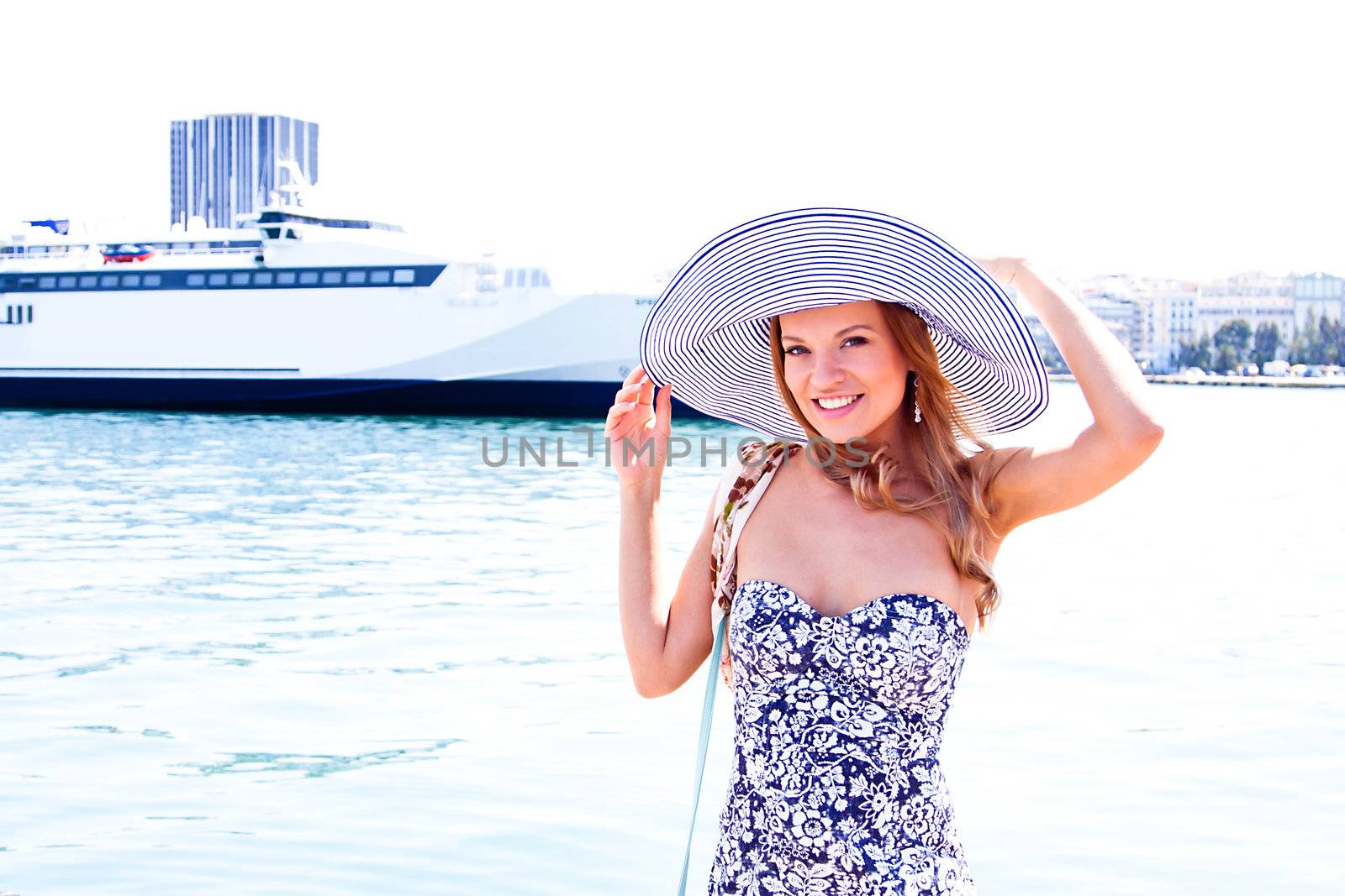 Portrait of a young and beautiful girl in the background of a large ocean liner