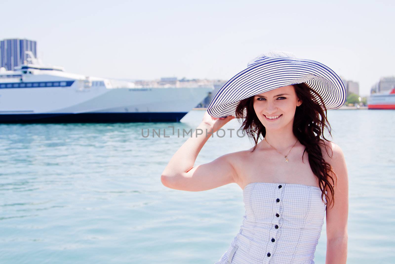 Portrait of a young and beautiful girl in the background of a large ocean liner