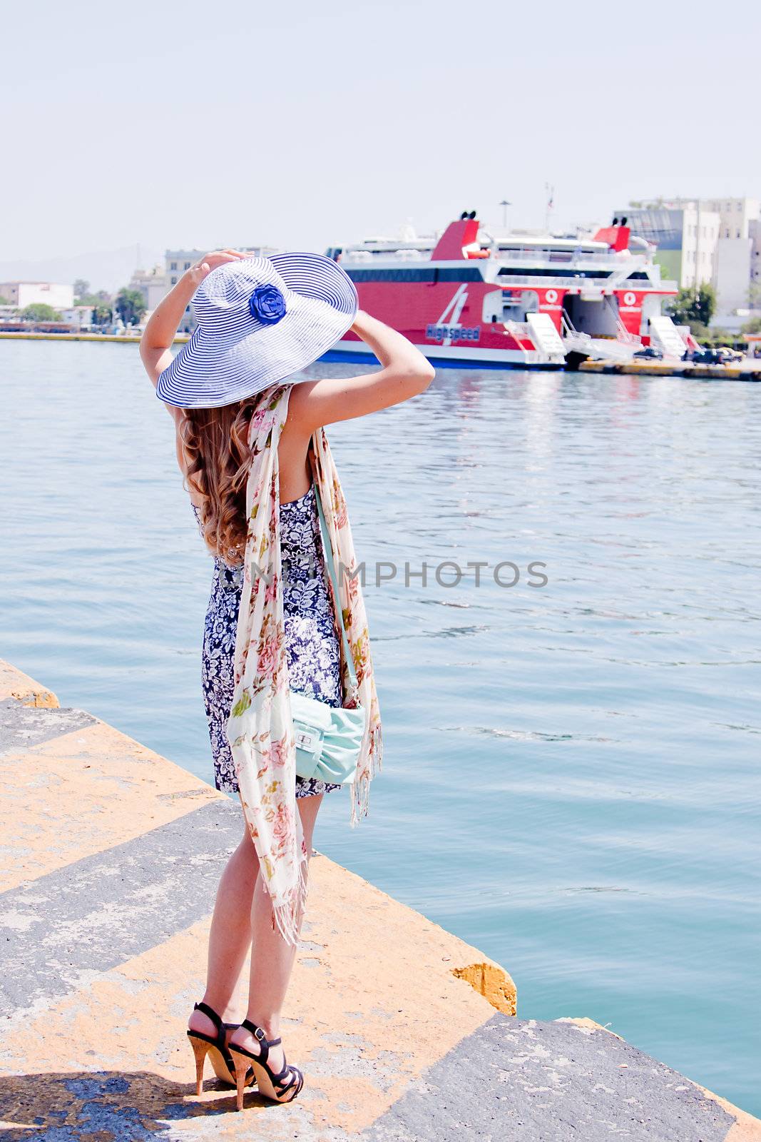 Portrait of a young and beautiful girl in the background of a large ocean liner