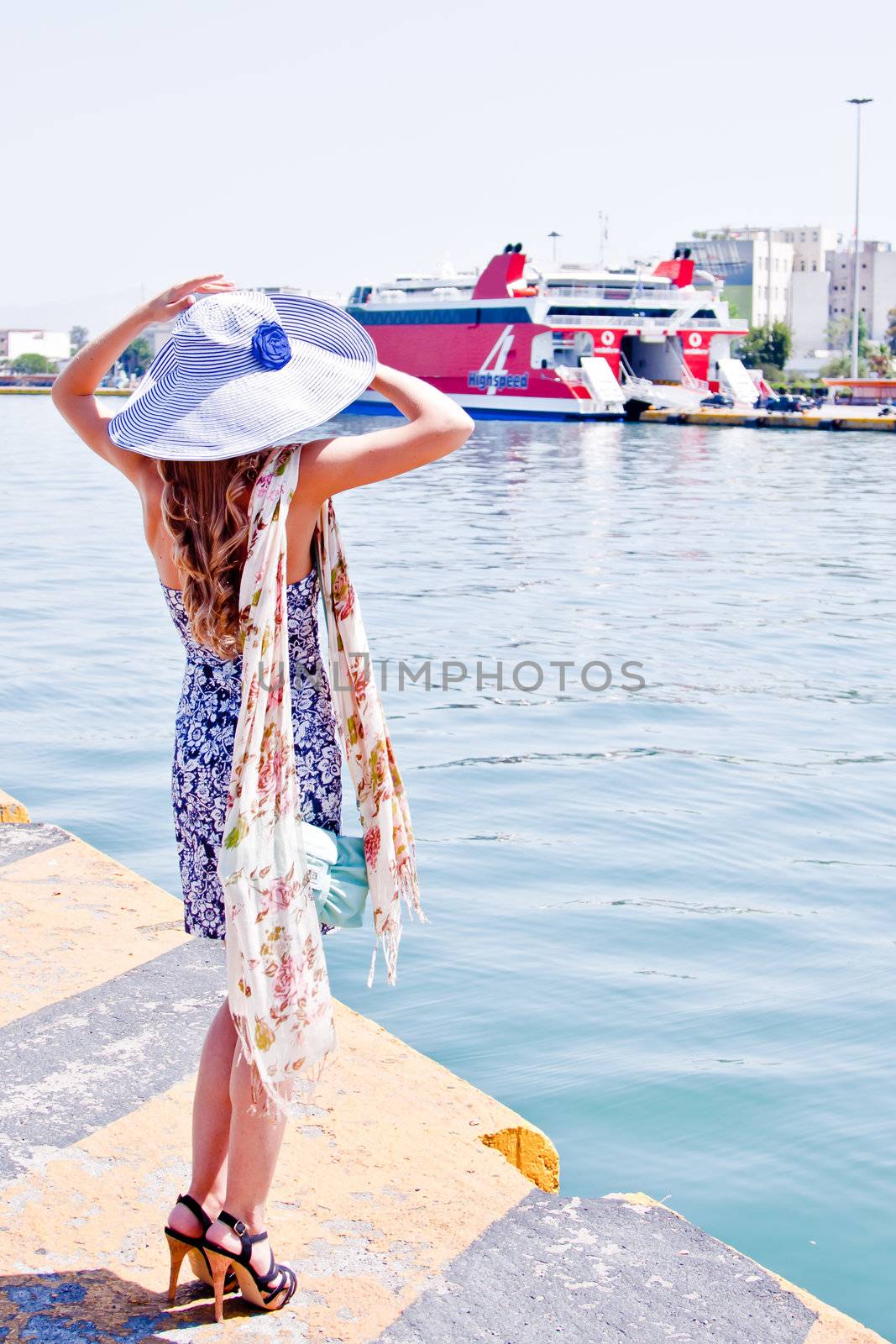 Portrait of a young and beautiful girl in the background of a large ocean liner