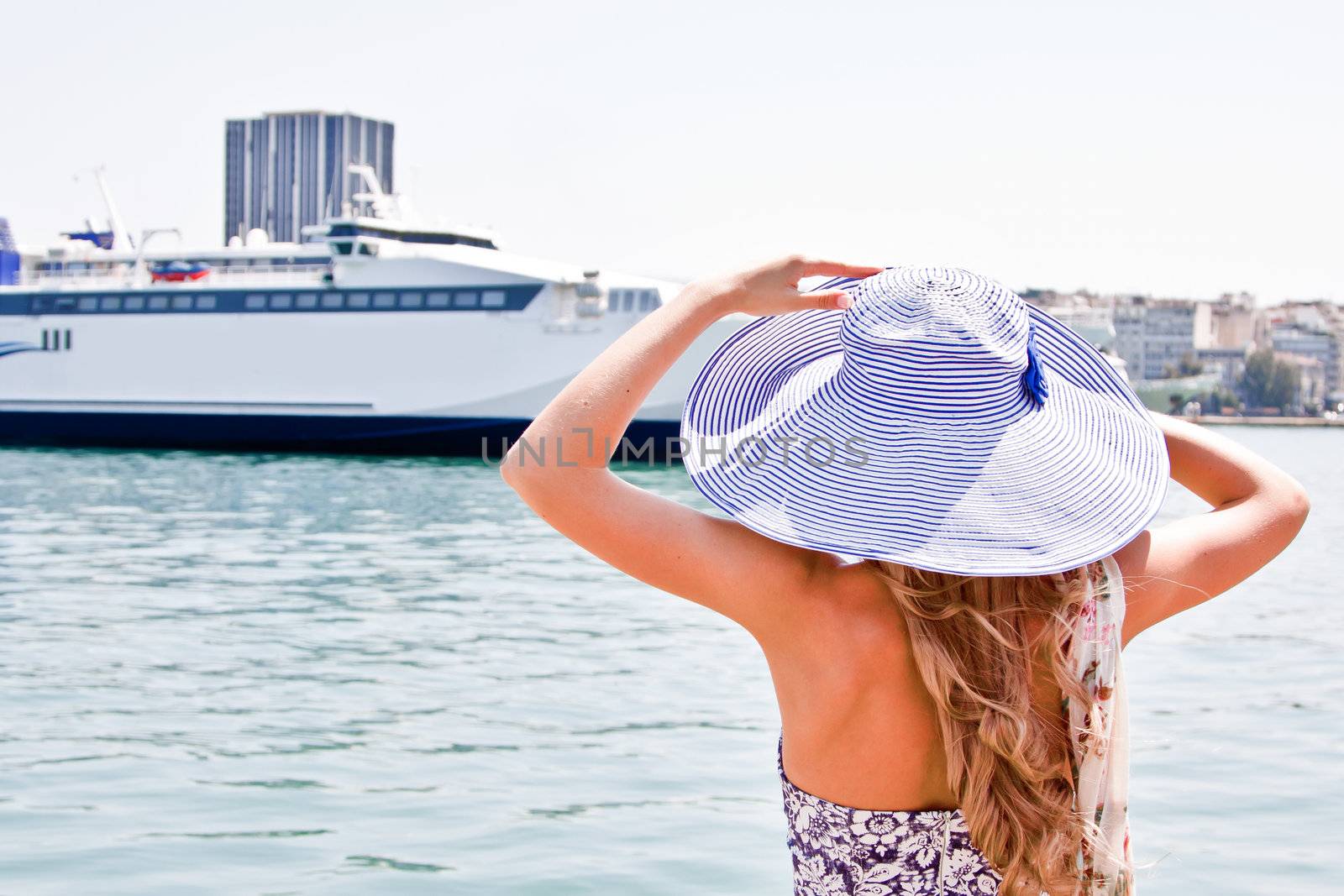 Portrait of a young and beautiful girl in the background of a large ocean liner