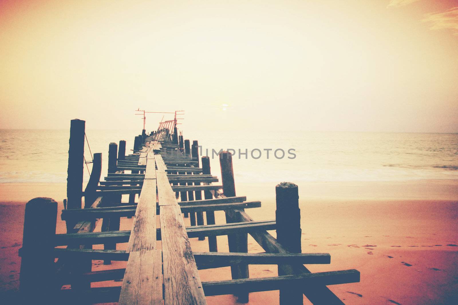 Old wood bridge to the sea sunset 