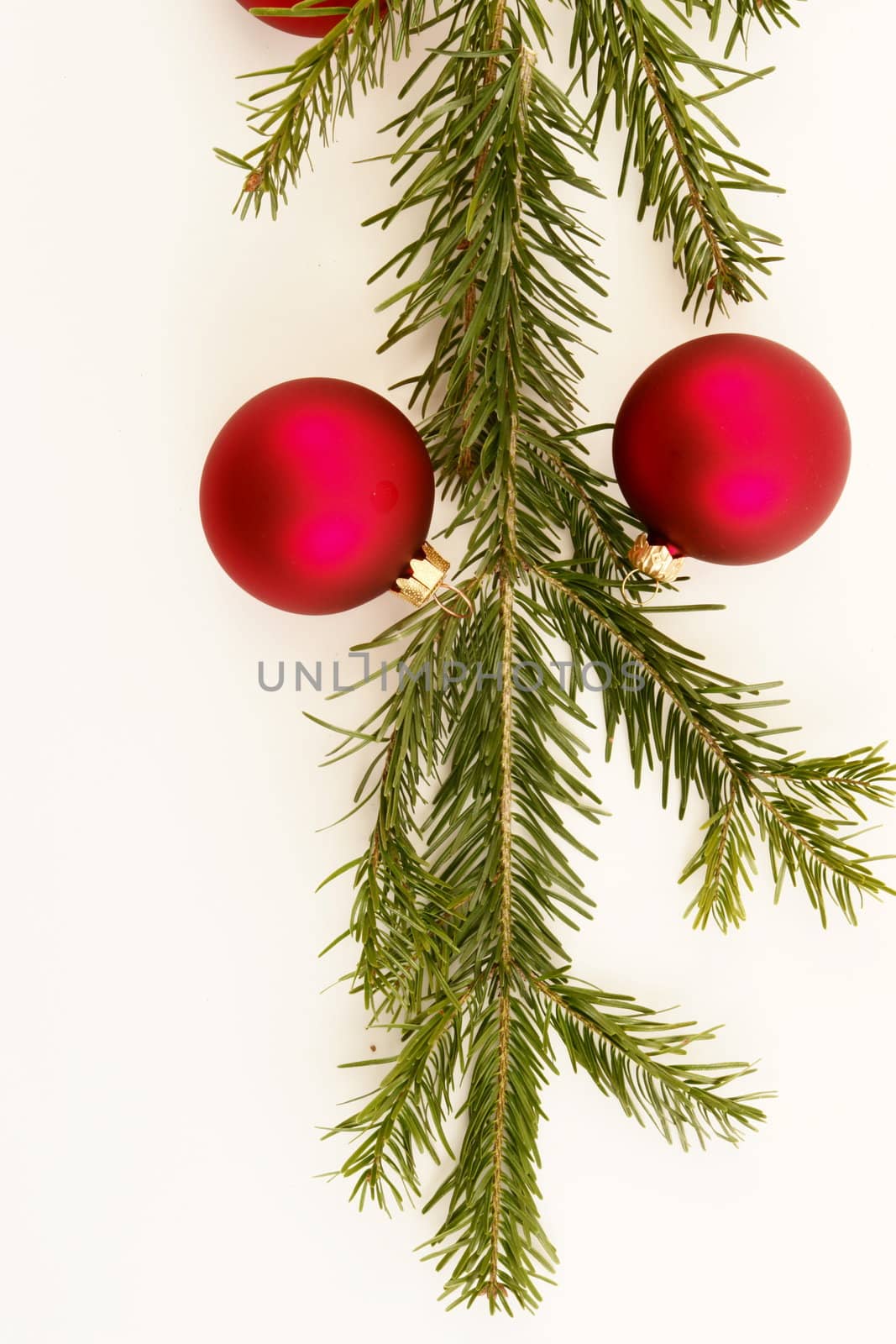 Border of red christmas garland with baubles and ribbons on white.