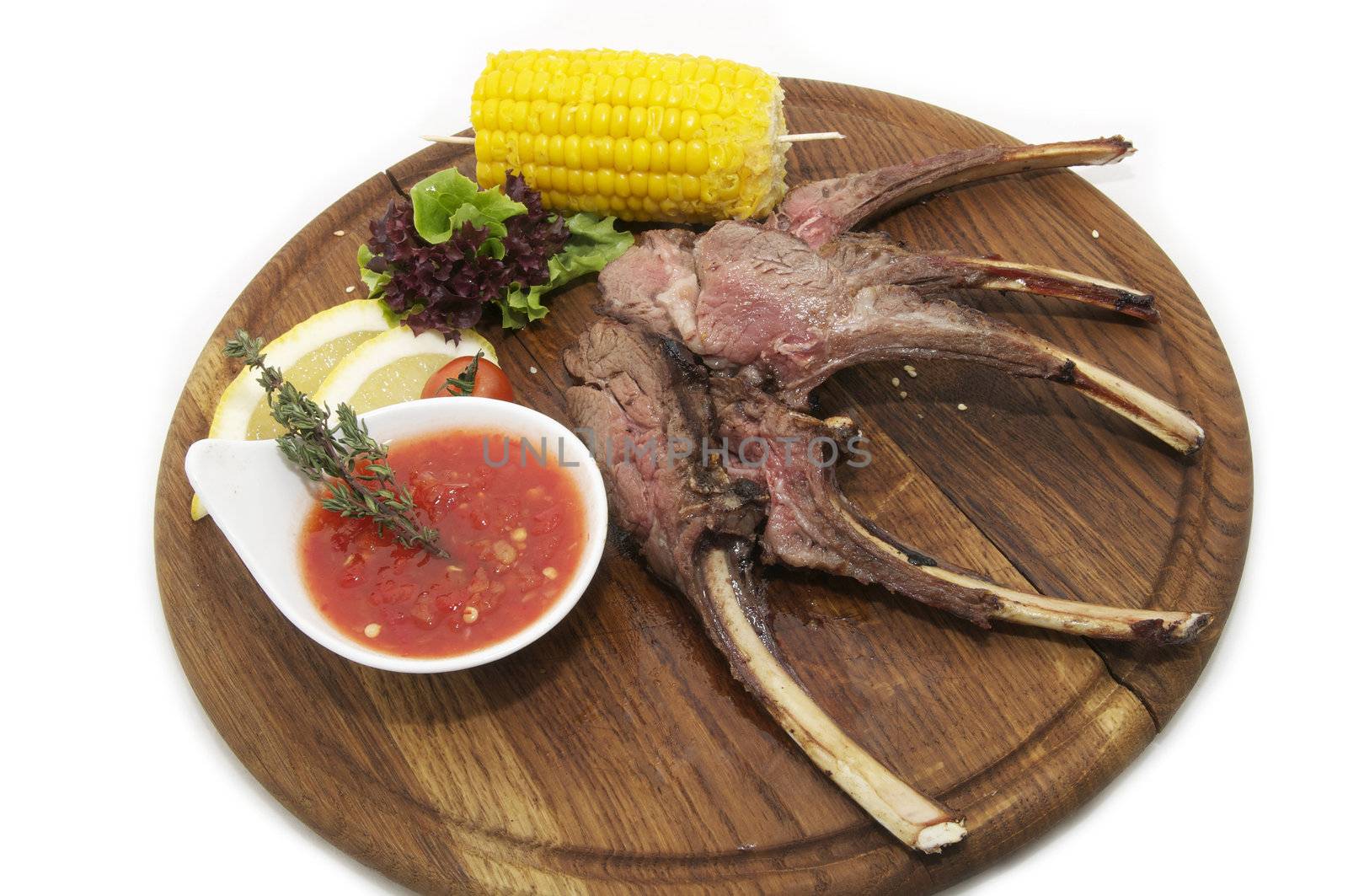 rib roast on the plate with the sauce and corn