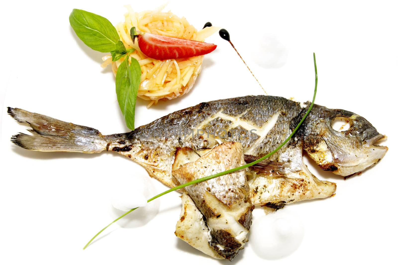 baked fish with vegetables on a white plate