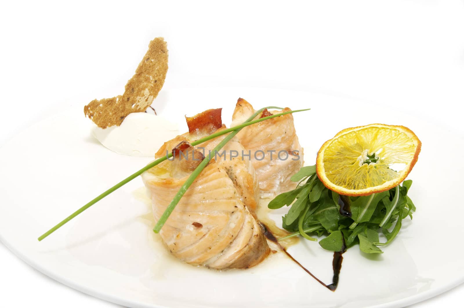 Fried fish with greens and rolls on a plate