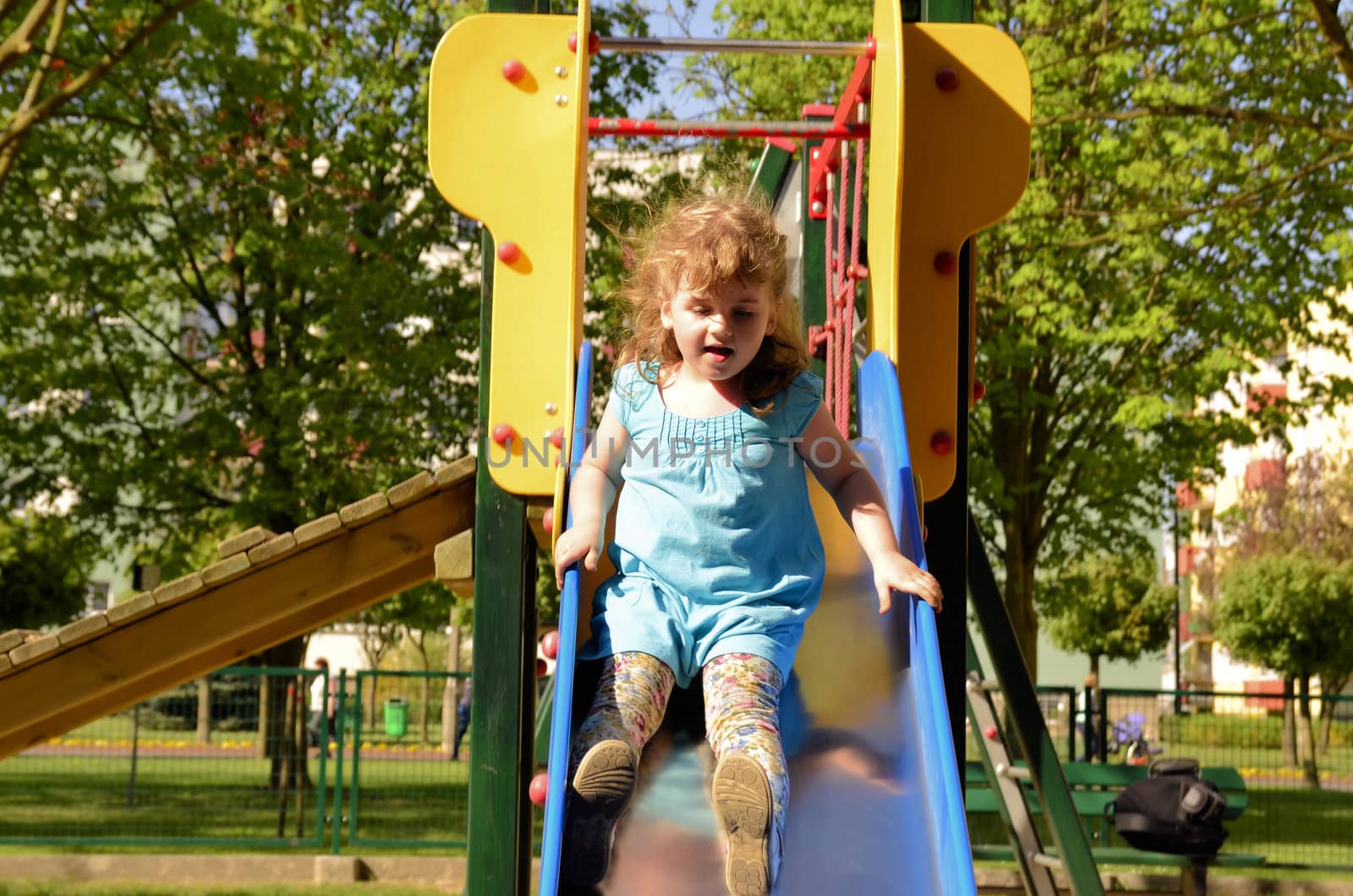 The photograph shows Little girl on the slide.