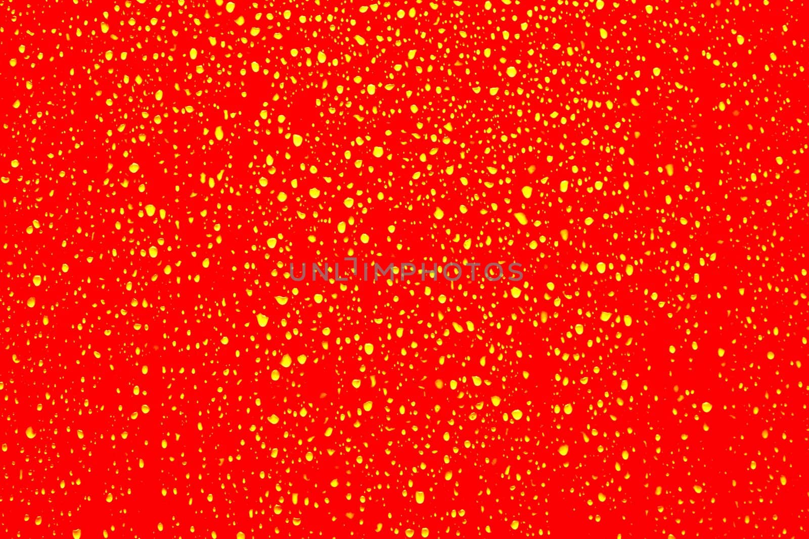 Yellow water droplets on a red surface