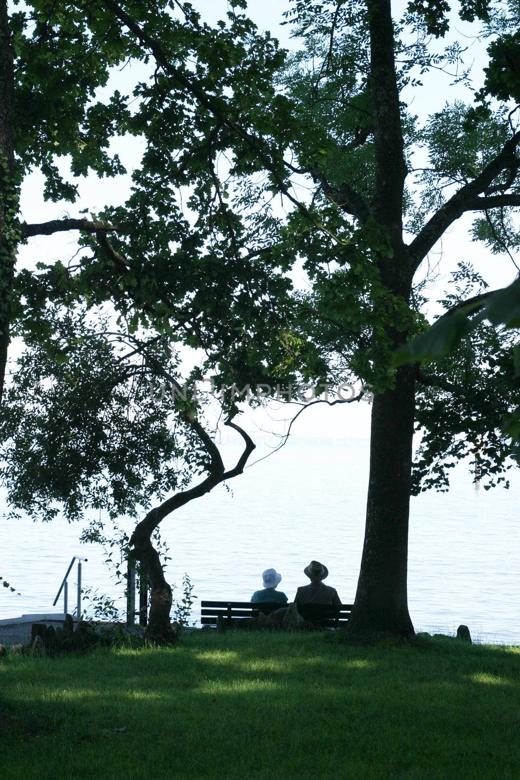 an elderly couple enjoying their retirement on a bench......