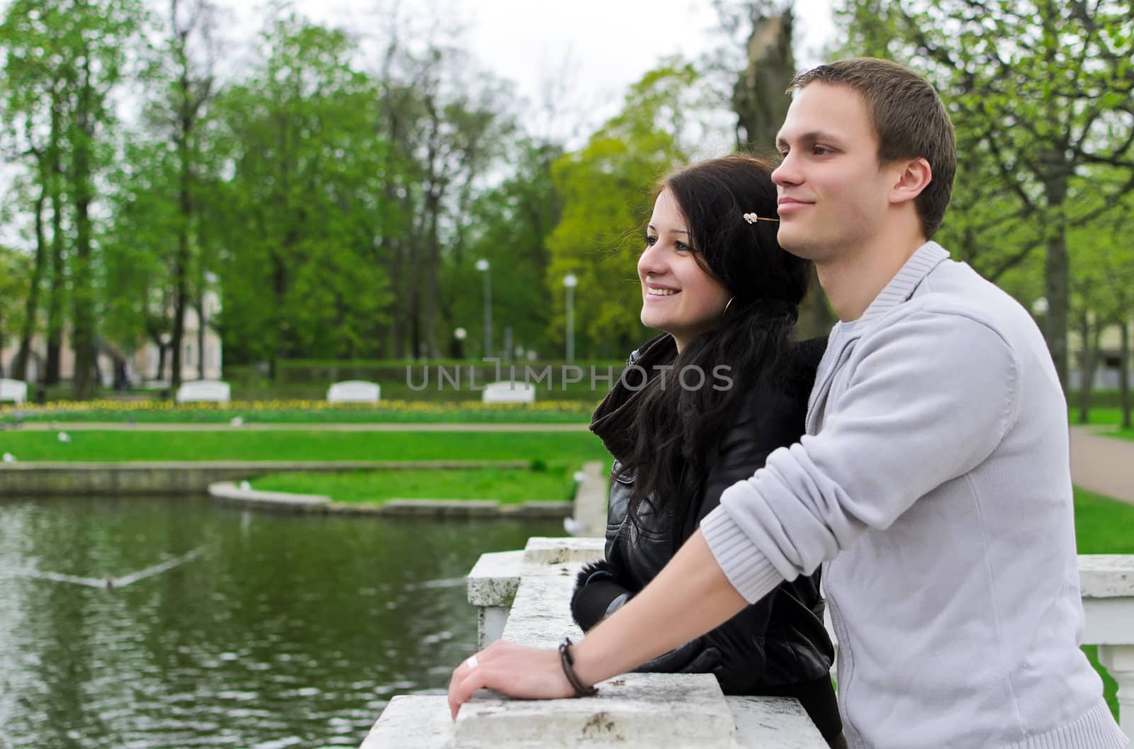 Cute couple looking at a pond in the park