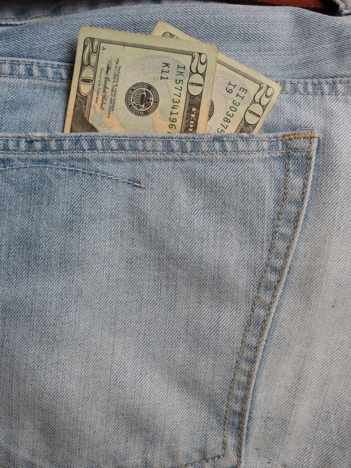 American blue jeans pocket filled with USD banknotes money 