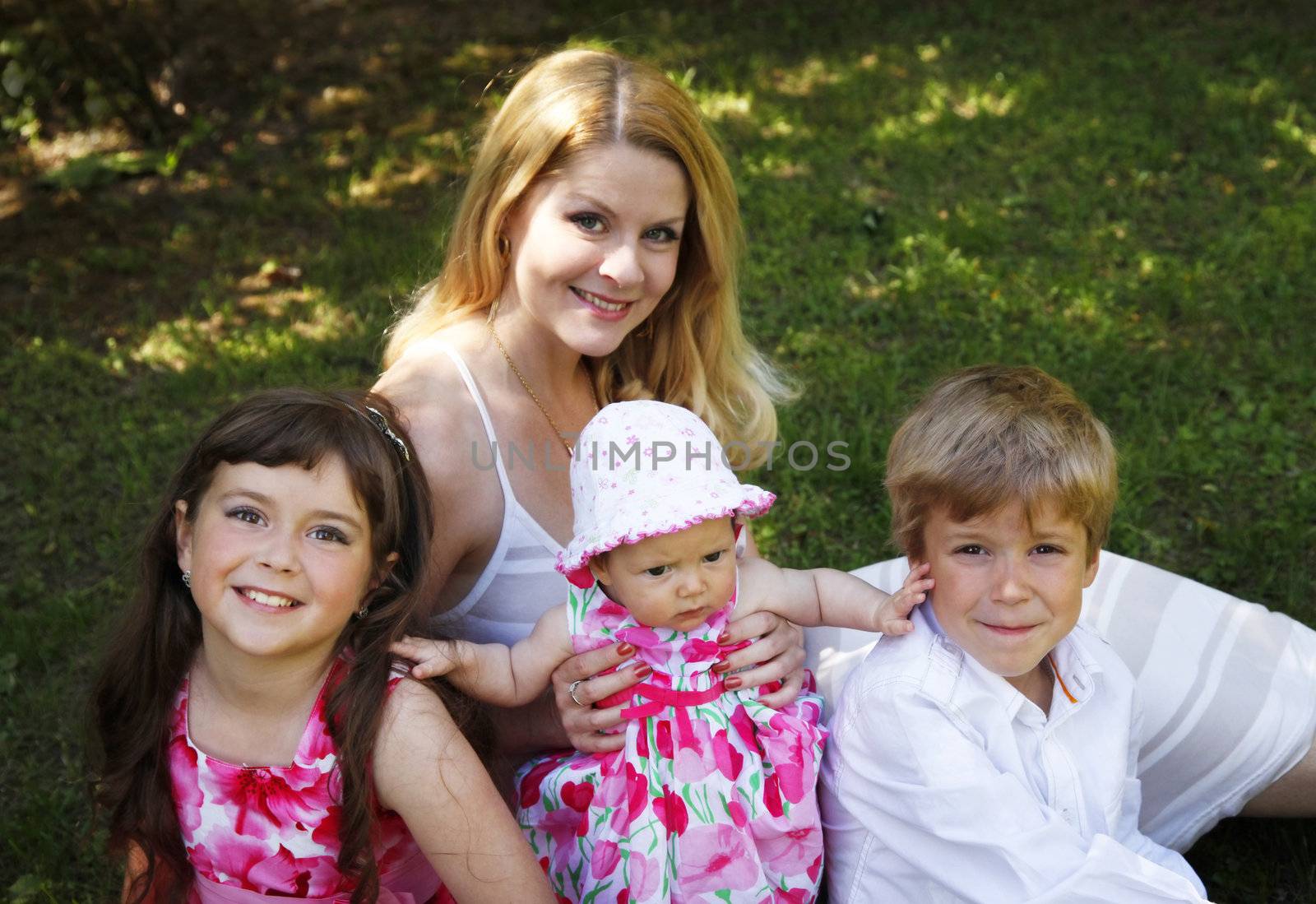 Portrait of beautiful happy smiling mother with children outdoor, on nature