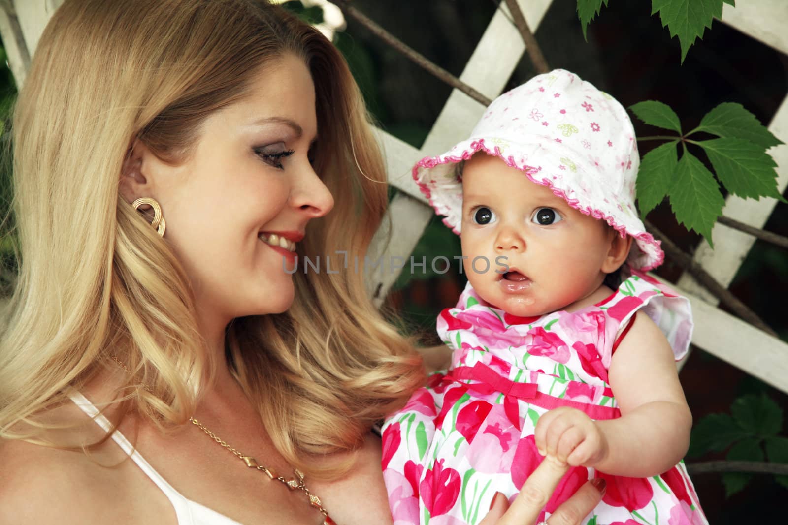 Portrait of beautiful happy smiling mother with baby outdoor, on nature