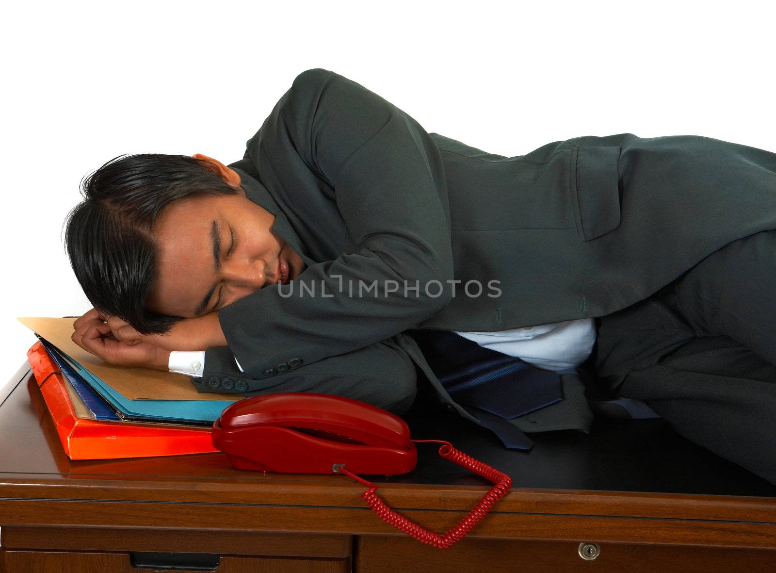 Tired Businessman Lying On His Desk by stuartmiles