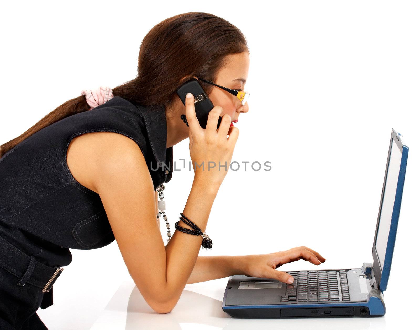 Young Girl Talking On The Telephone And Using A Notebook Computer