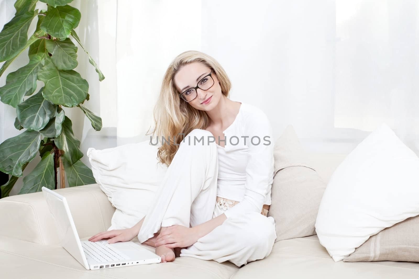 young blonde woman on couch with notebook