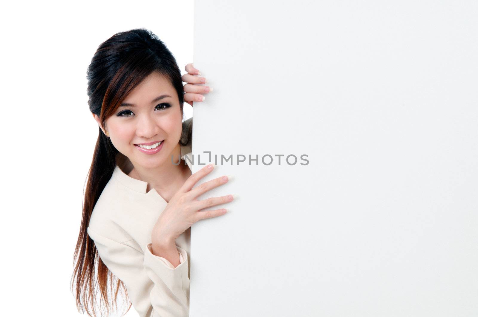 Portrait of a happy young businesswoman holding blank billboard over white background.