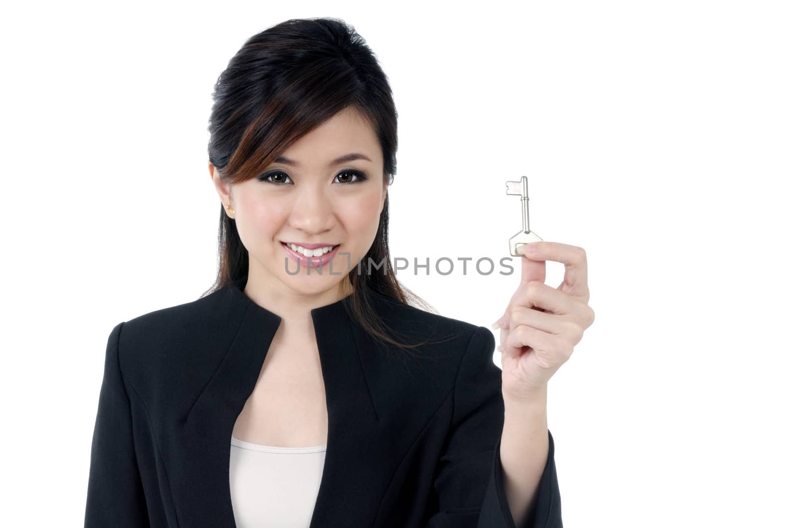 Portrait of an attractive young businesswoman holding a key over white background.
