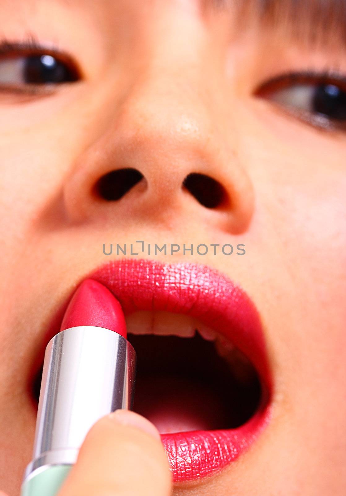 Woman Adding Finishing Touches To Her Make Up By Applying Lipstick