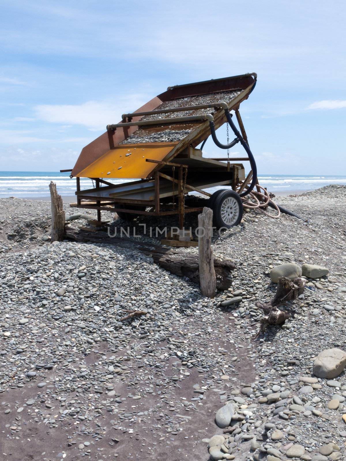 Metal sluice box on placer mining claim for extracting alluvial gold dust from gravel beach of West Coast of New Zealand South Island