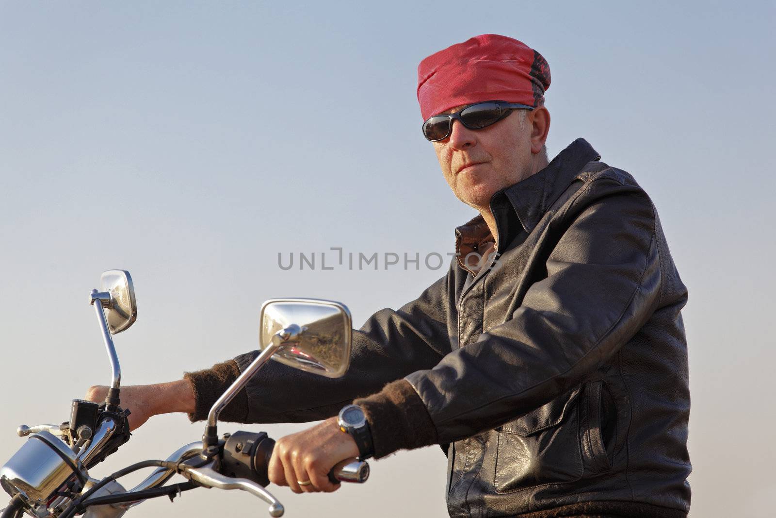 Side on take of w white motor biker posing with sun glasses and red bandanna