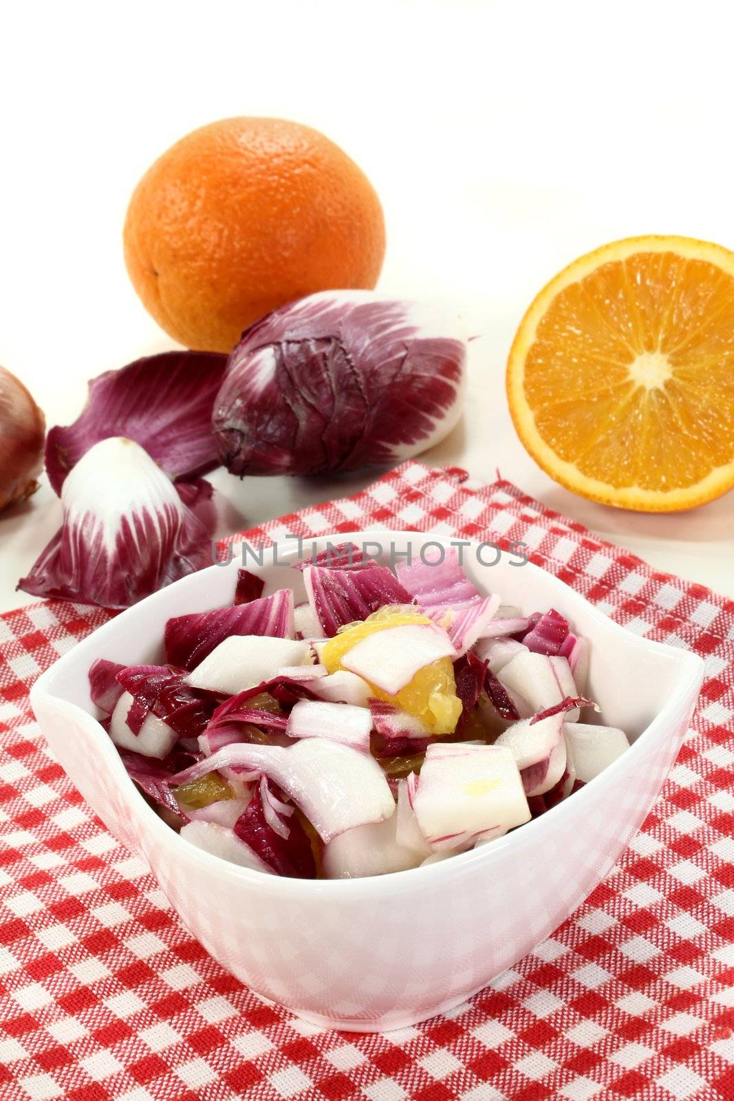 a bowl of chicory salad with shallots and orange