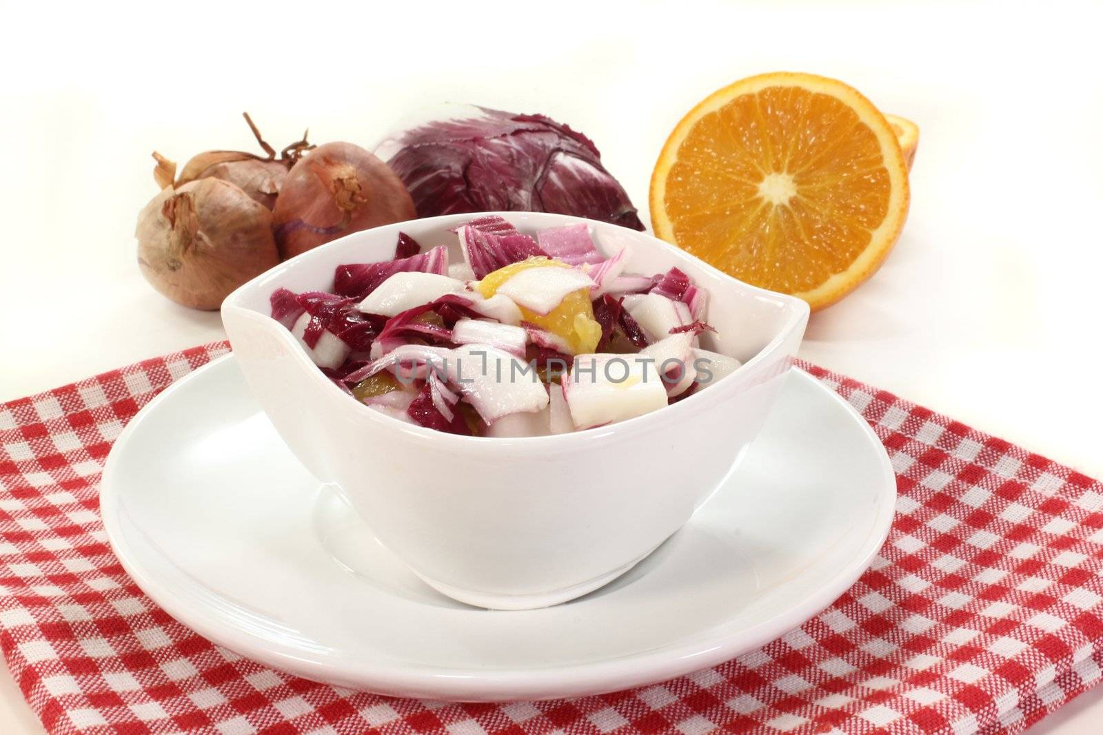 a bowl of chicory salad with shallots and orange