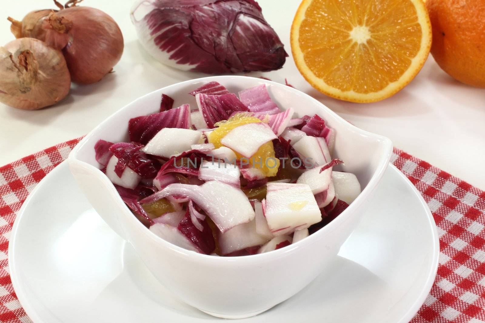 a bowl of chicory salad with shallots and orange