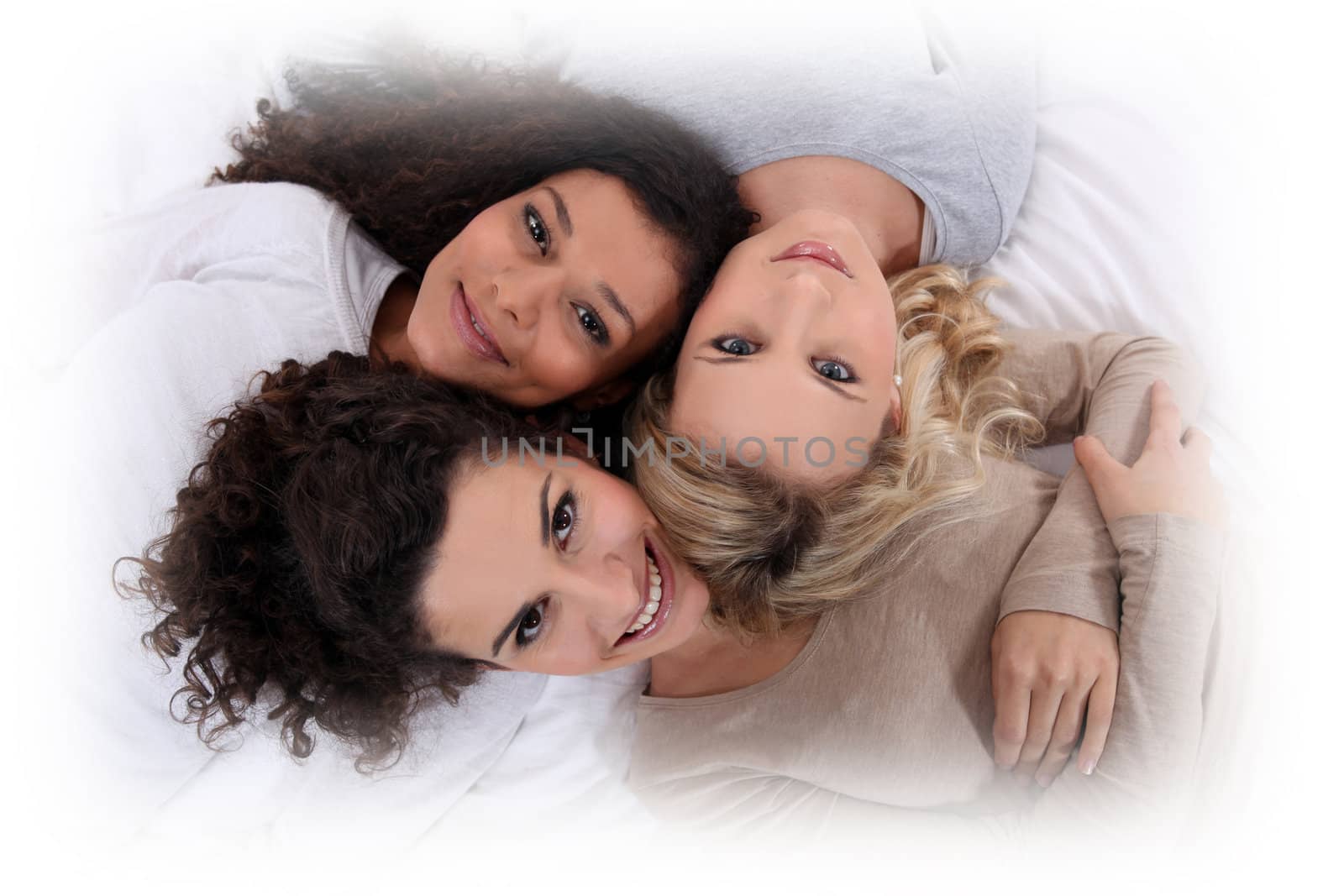 Three women laying next to each other by phovoir