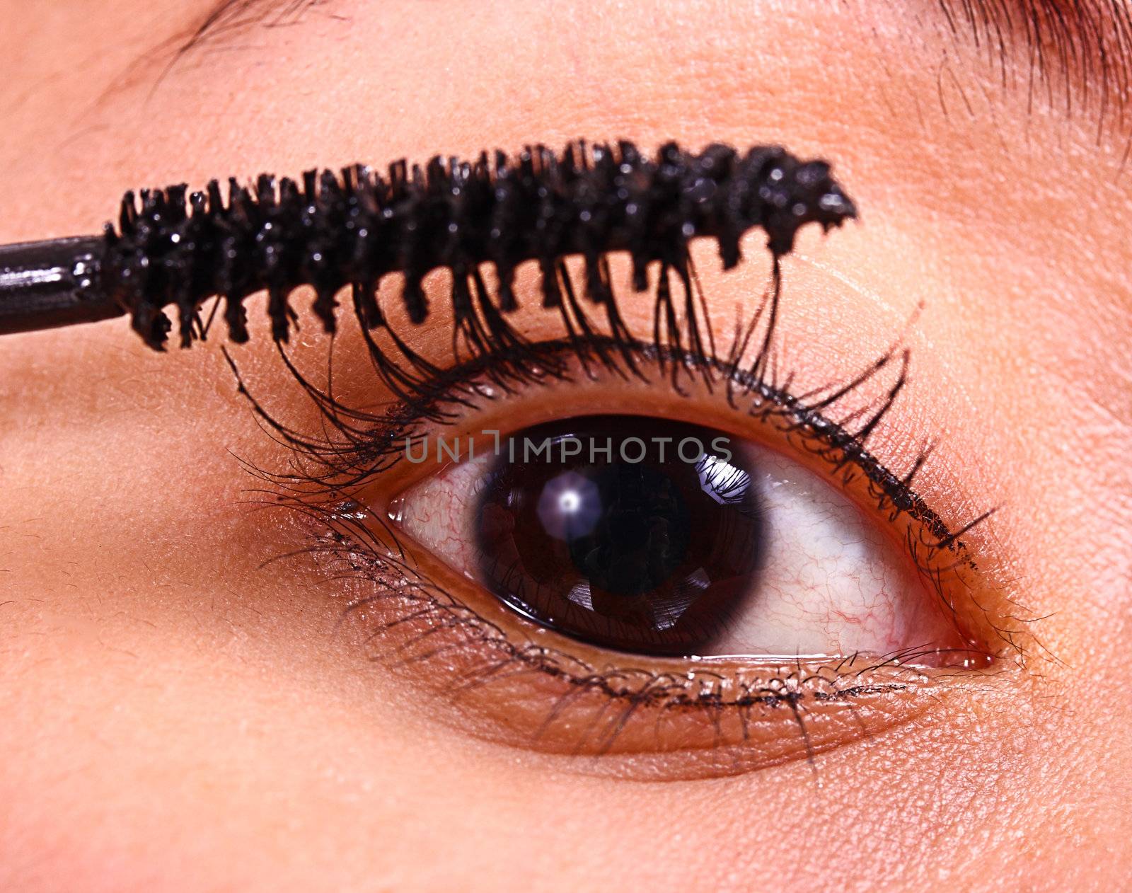 Girl Applying Mascara As Part Of Make Up Regime