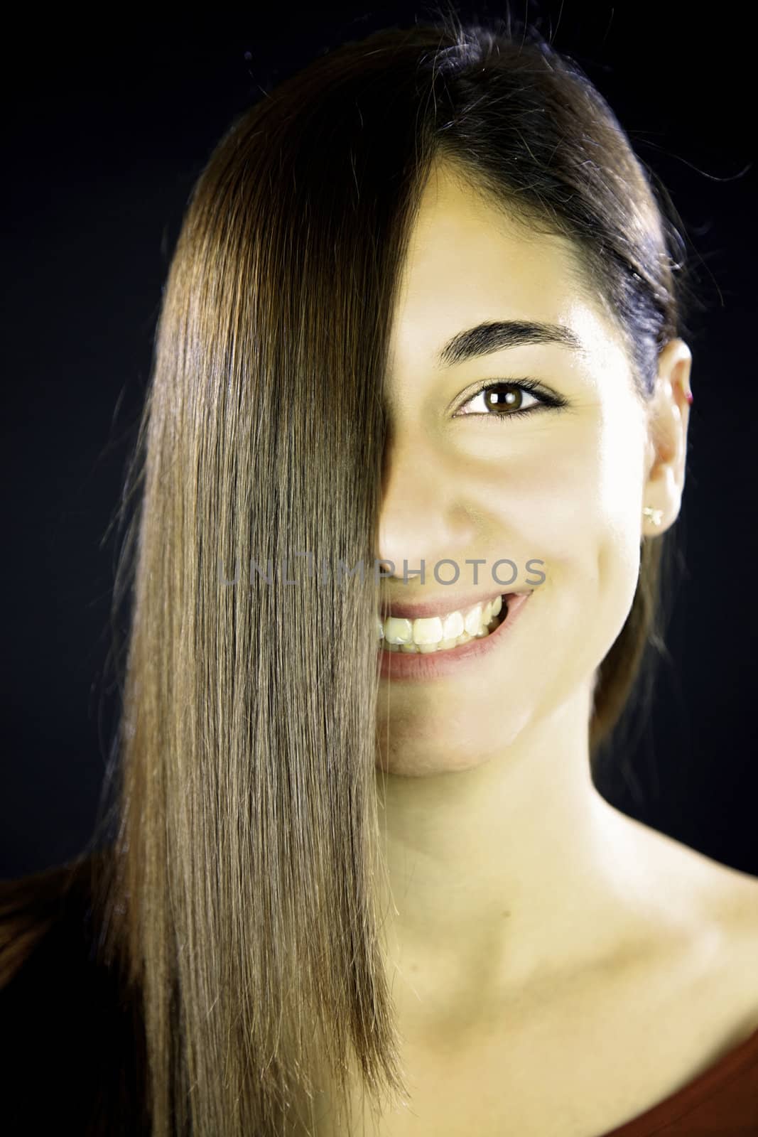 woman with long brunette straight hair in front of her face