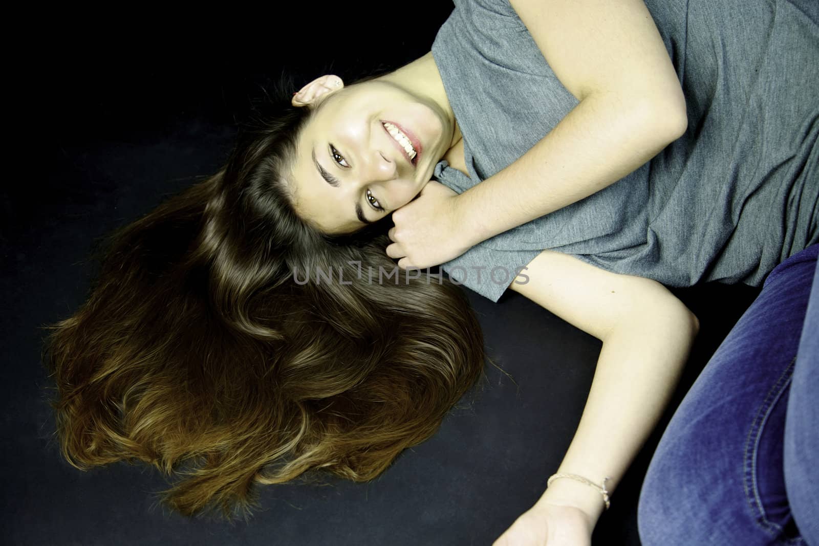 Girl with long hair on the ground smiling