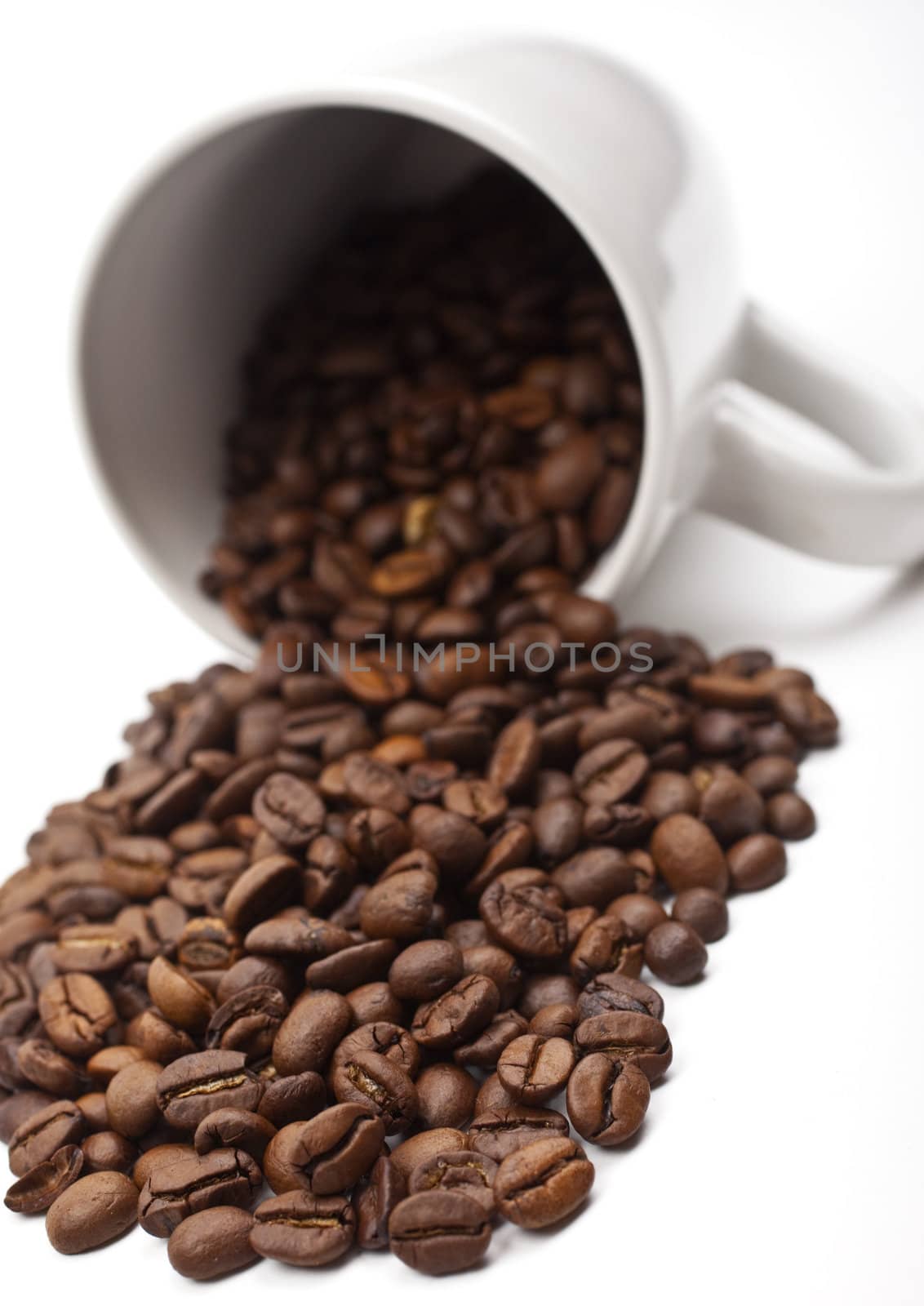 Coffee Beans spilling from a mug.