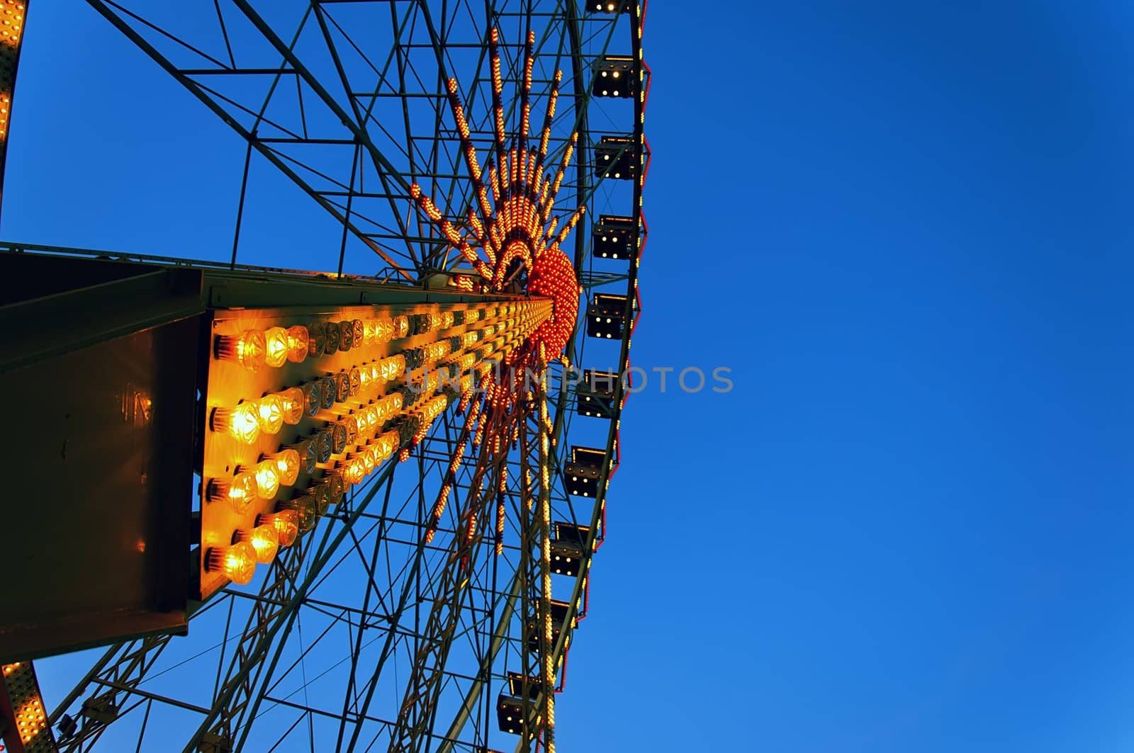 Ferris wheel at dusk with the included illumination, close-up view from the side.