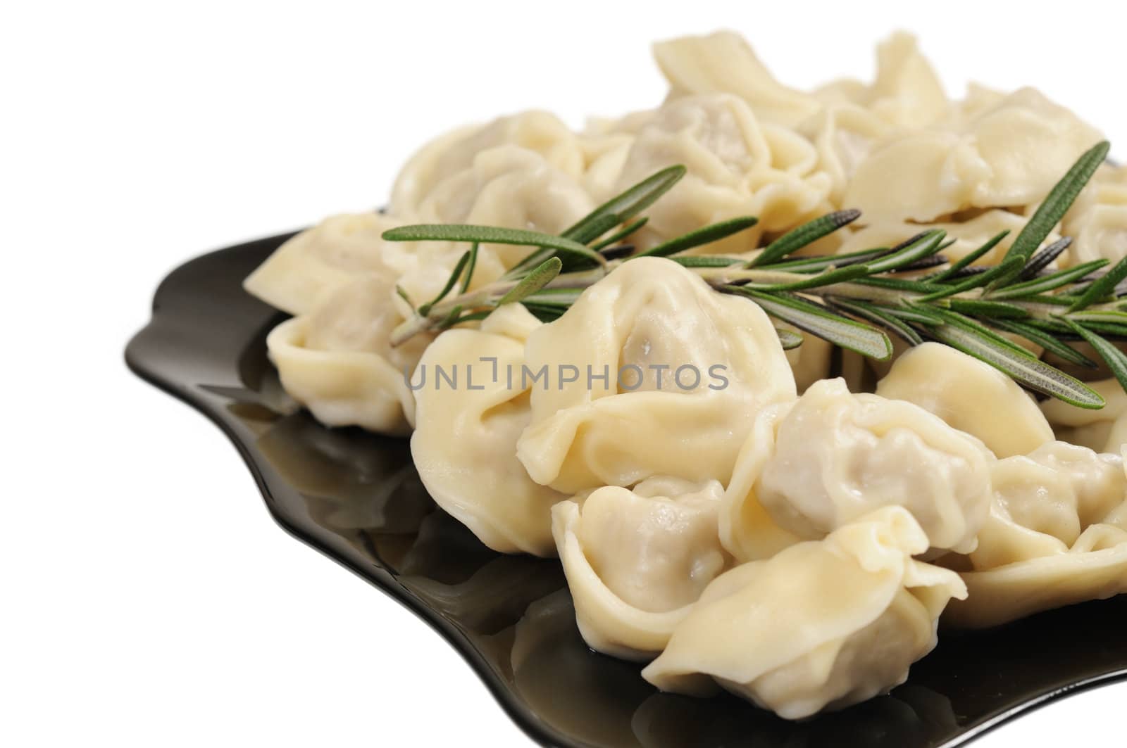 Ready to eat ravioli on a plate. Decorated with rosemary. Isolated on white.