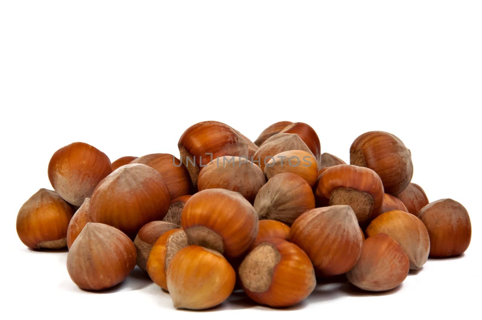 Handful of fresh hazelnuts isolated on a white background, closeup.