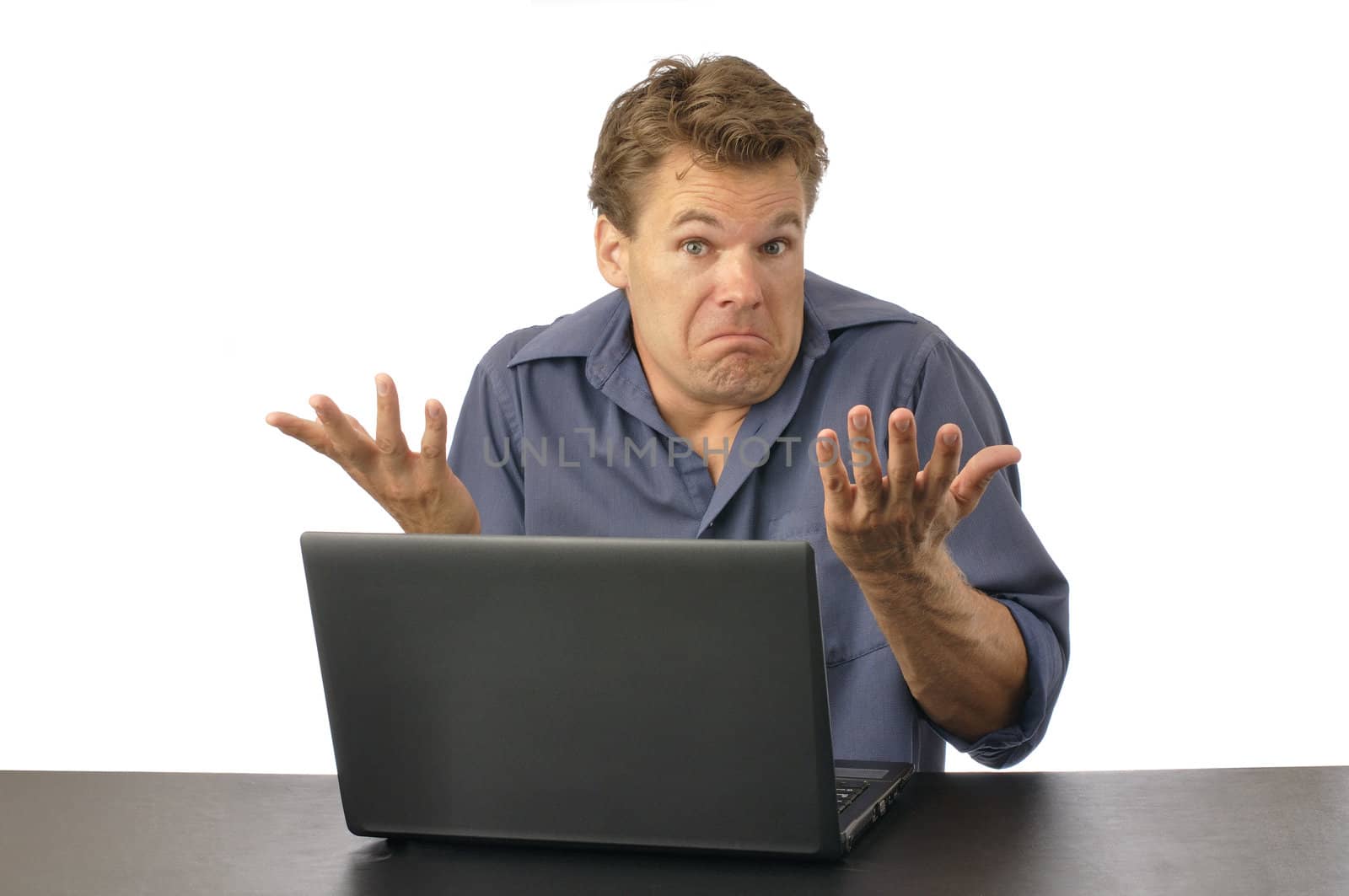 Puzzled man at computer shrugs shoulders and expresses lack of knowledge