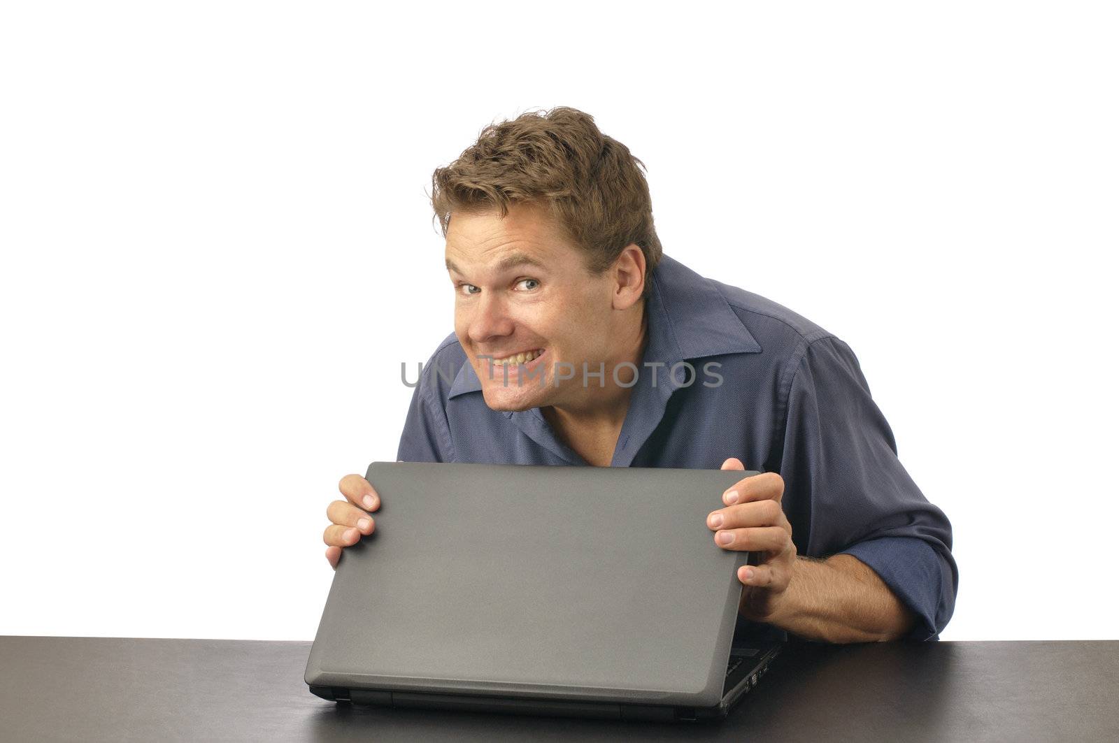 Man with guilty grin carefully closes laptop