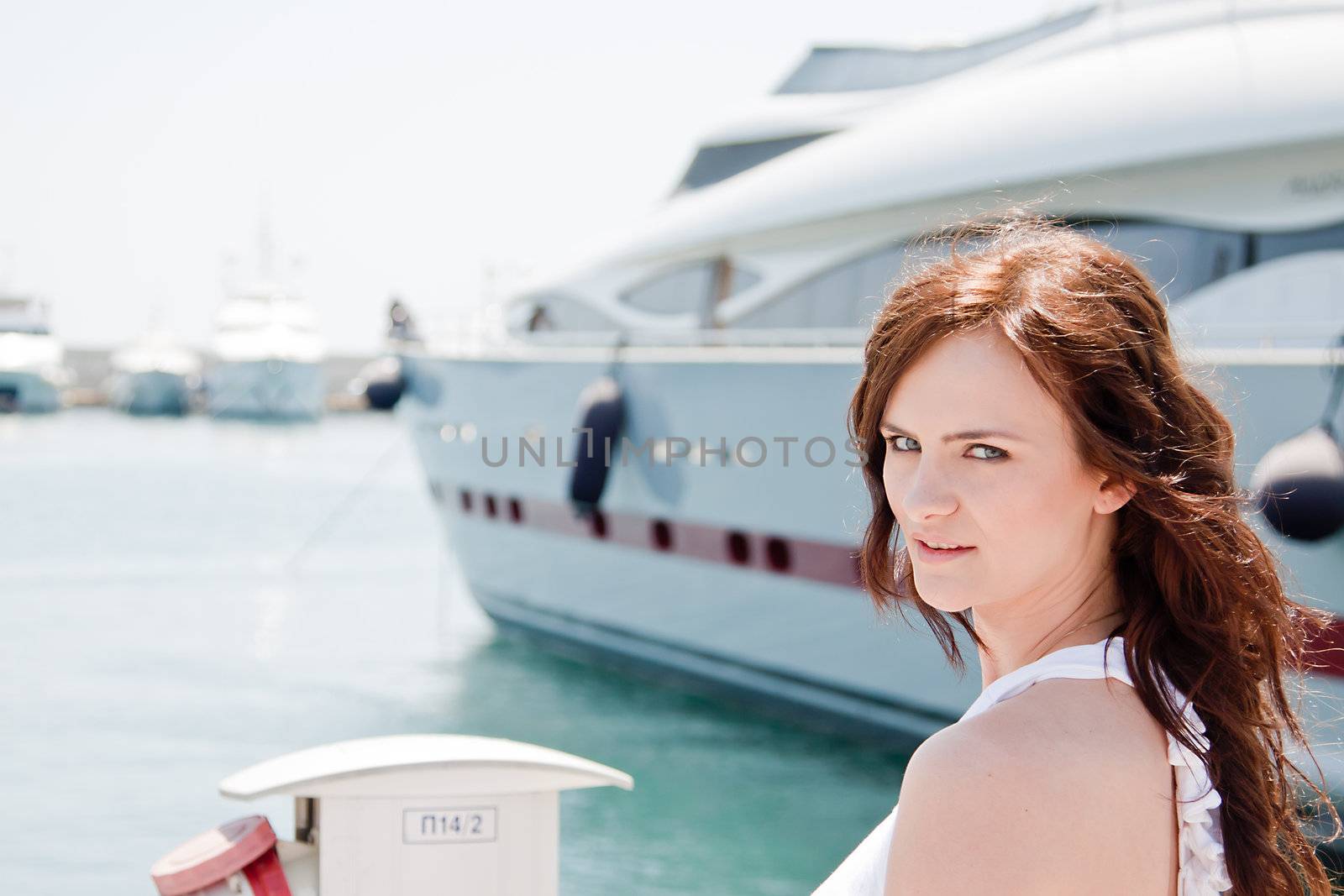 Portrait of a young and beautiful girl in the background of a large ocean liner