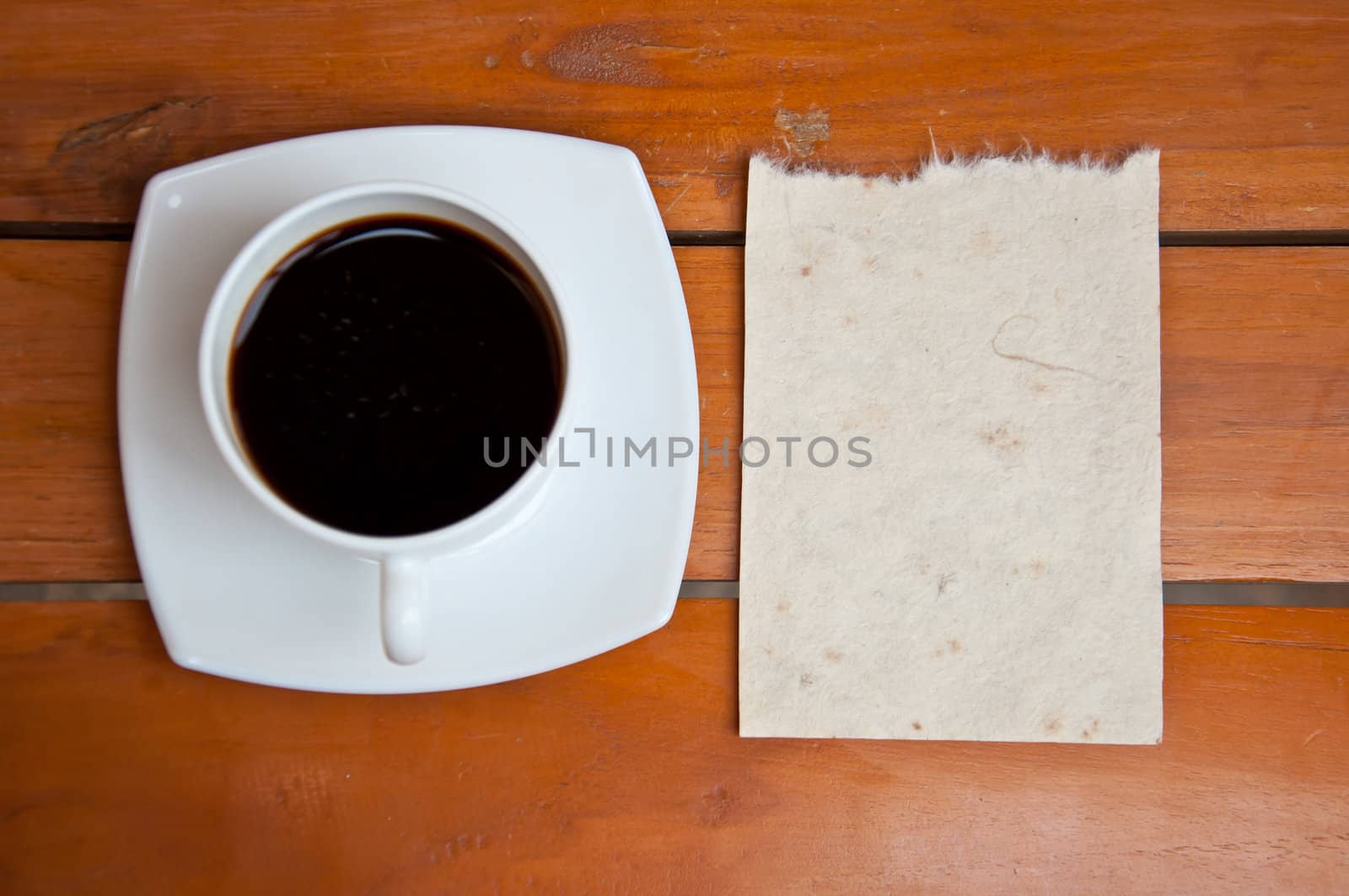 blank paper and black coffee on wood background