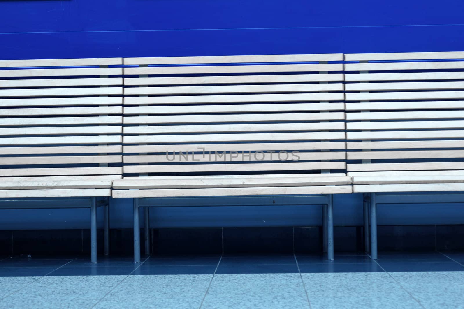 row of wooden benches on a blue background