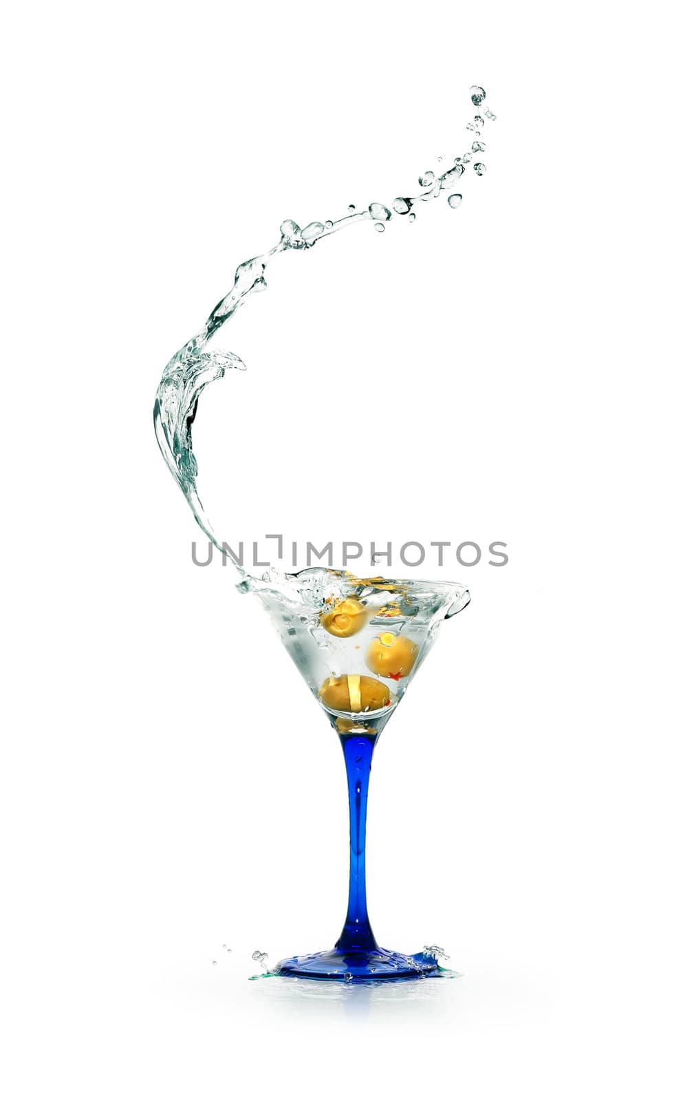 Stylish martini glass with splashing liquid and olives on white background