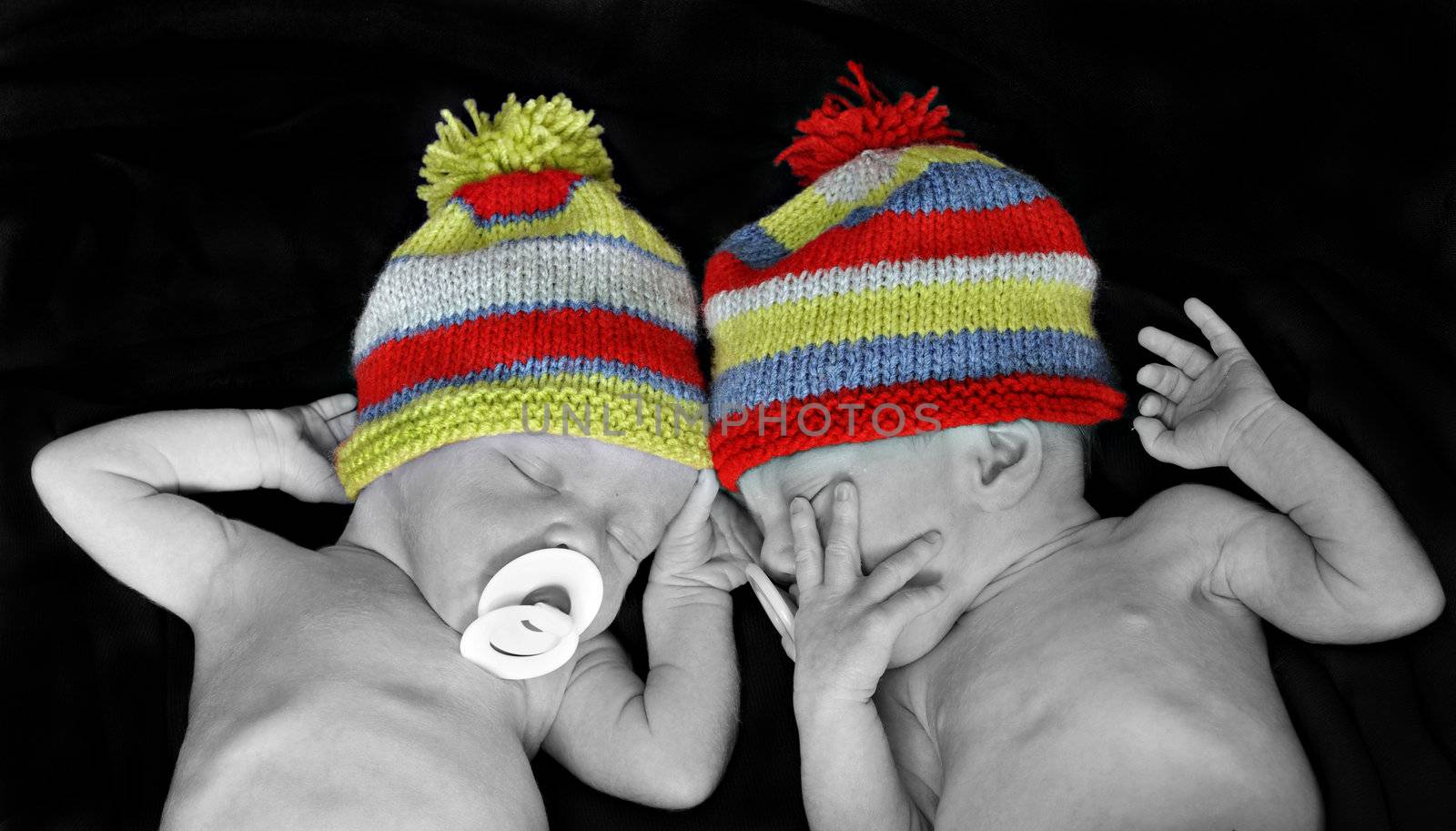 New born twins with colorful hats